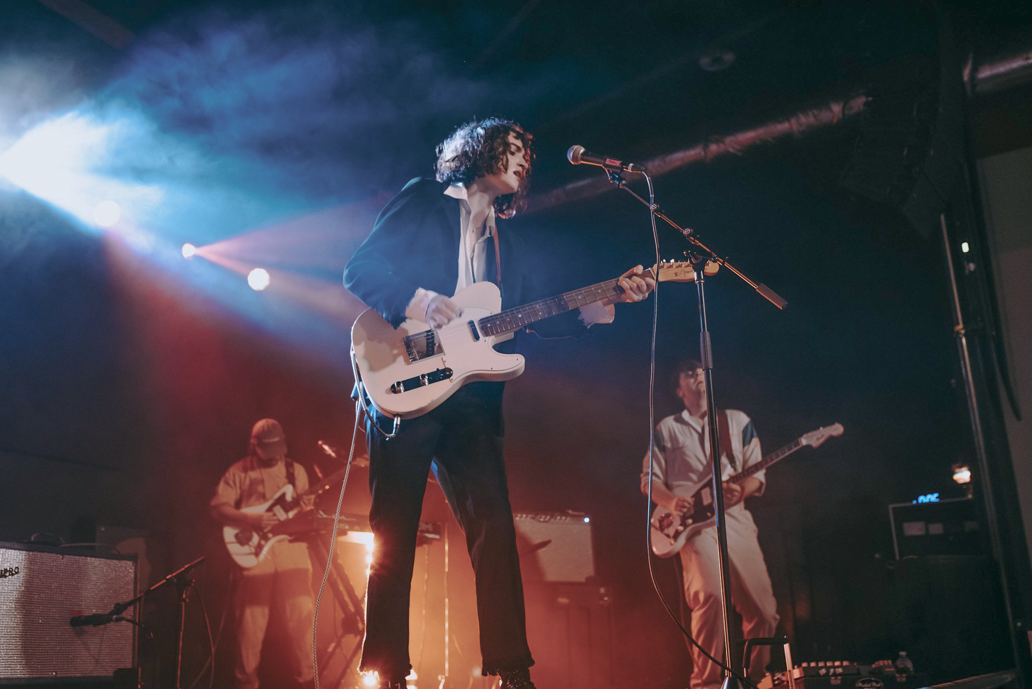 Dana Foote performing with two other band members in the back.